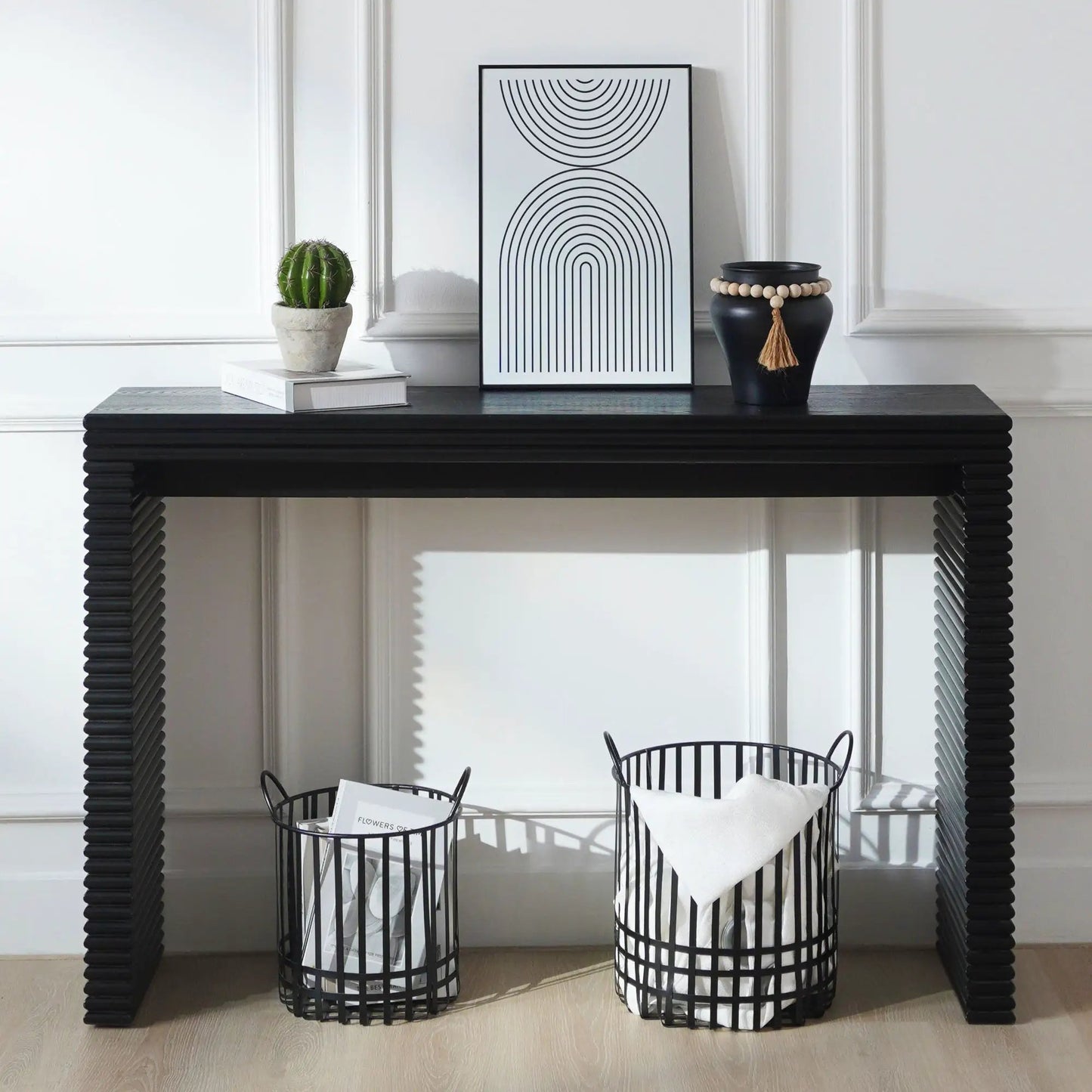 Modern console table with black ribbed legs, cactus, framed geometric art, and black vase on Tampa Home & Garden Store