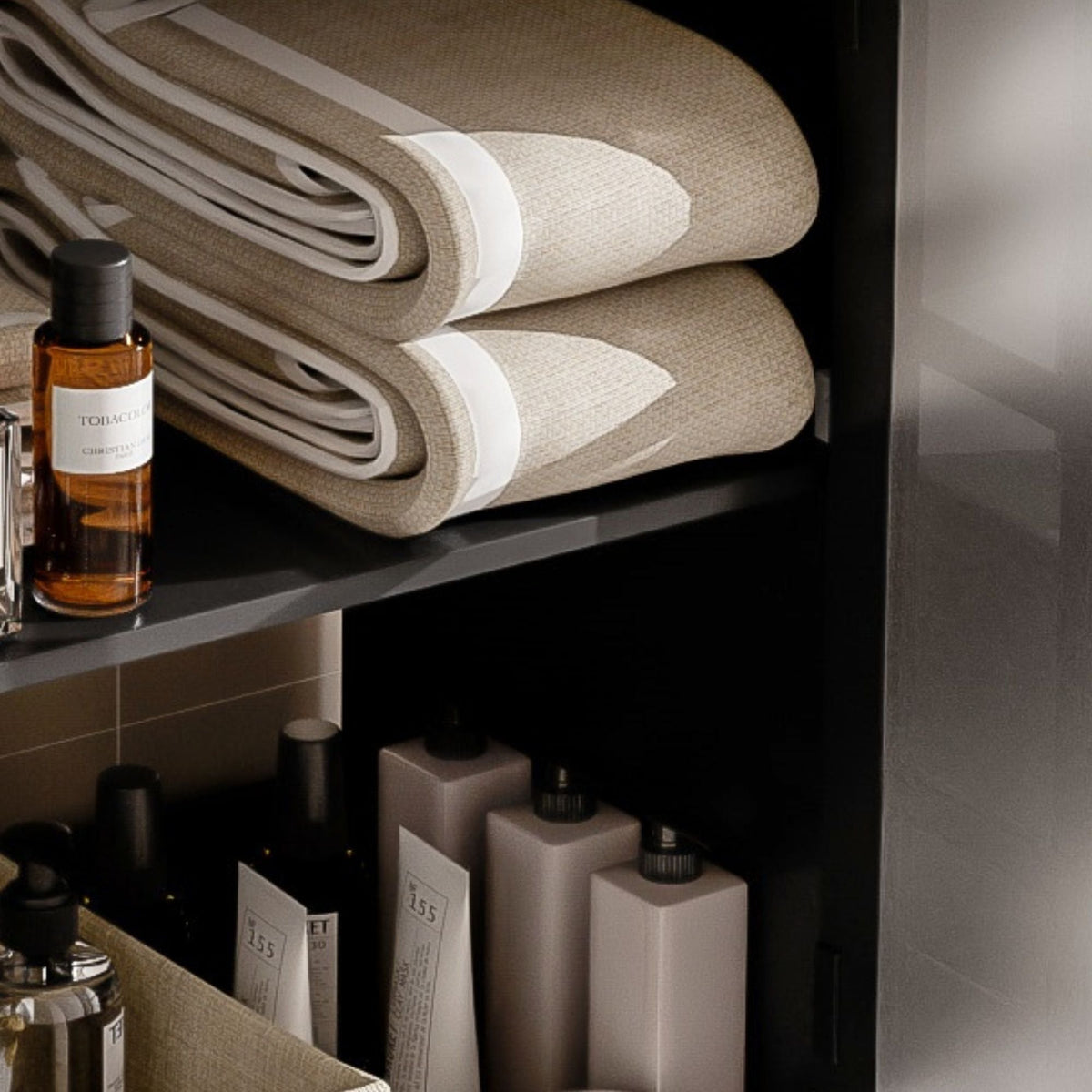 Vanities display with rolled beige towels and amber bottles on a dark shelf on Tampa Home & Garden Store