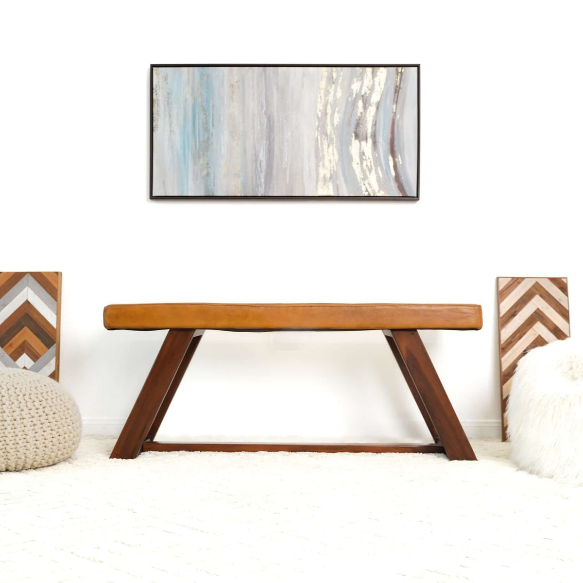 Light brown leather upholstered bench with hand stitching on a dark wood cross-legged frame on Tampa Home & Garden Store