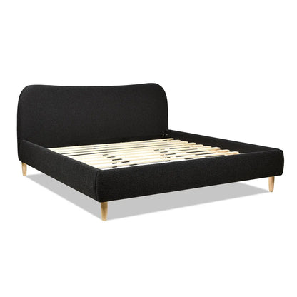 Roman curved headboard upholstered platform bed in black fabric with light wood legs on Tampa Home & Garden Store