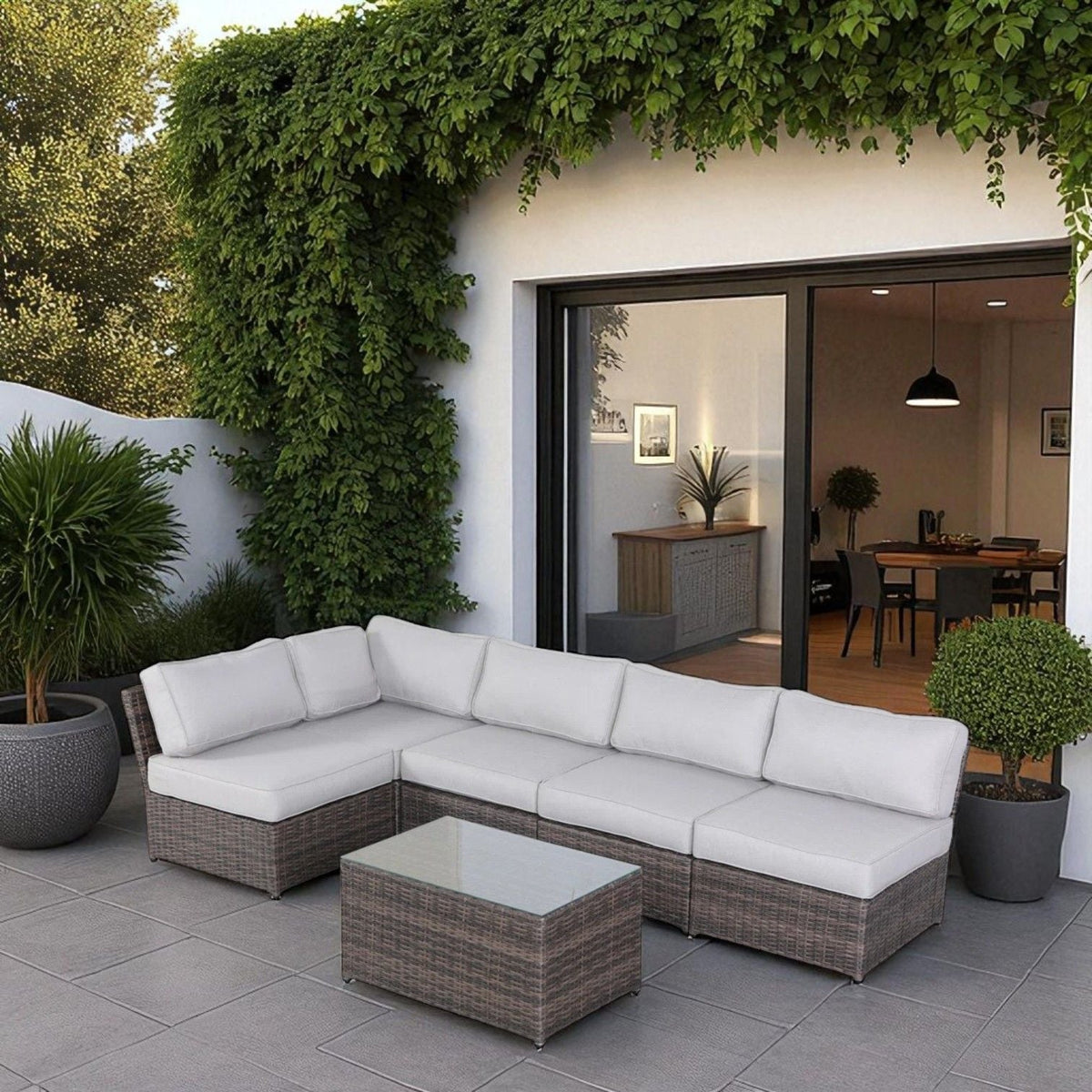 HouseOfZazla 2-piece outdoor wicker sectional with light gray cushions on a tiled patio with lush greenery on Tampa Home & Garden Store