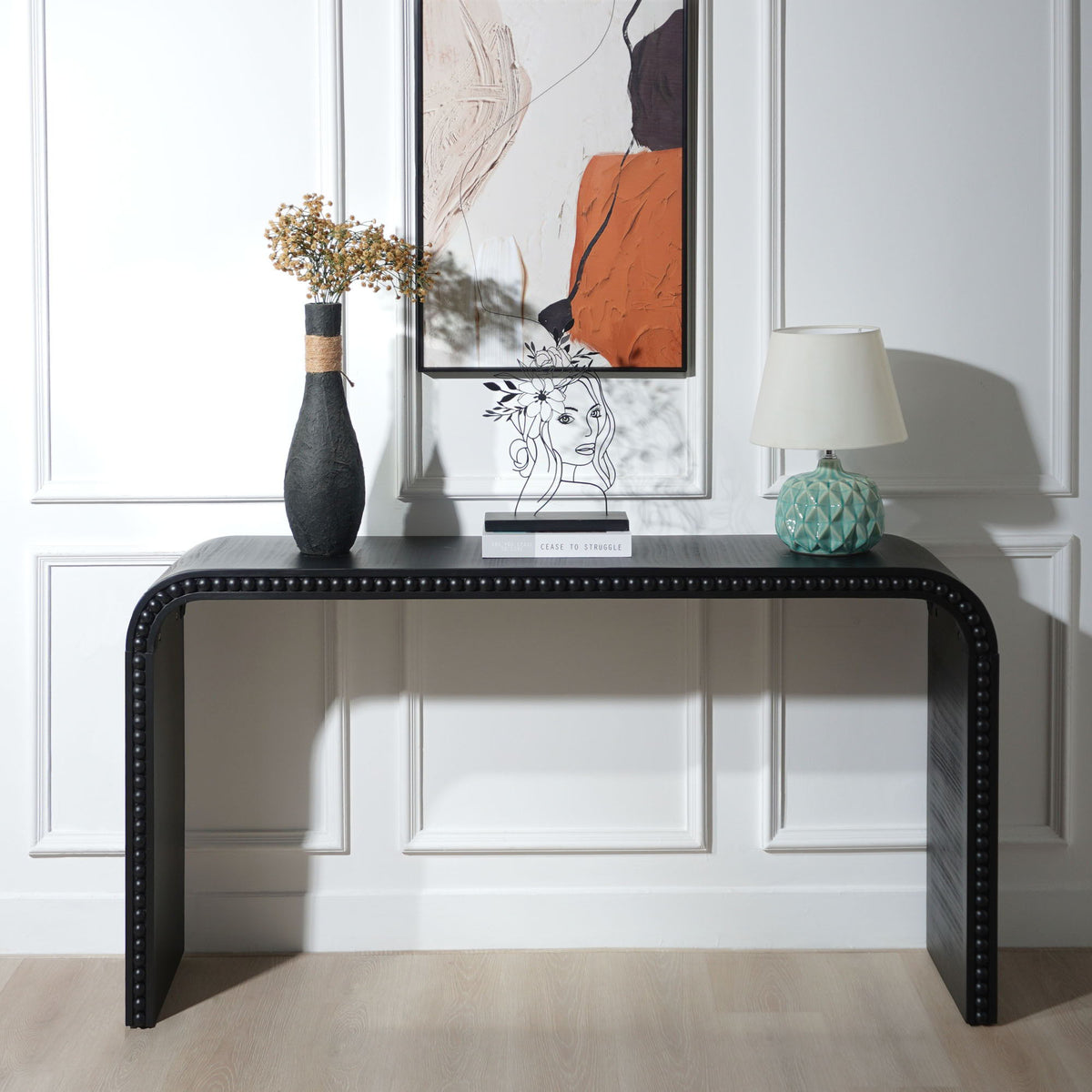 Waterfall Console Table in black with curved edges and nailhead trim, paired with vase and lamp on Tampa Home & Garden Store