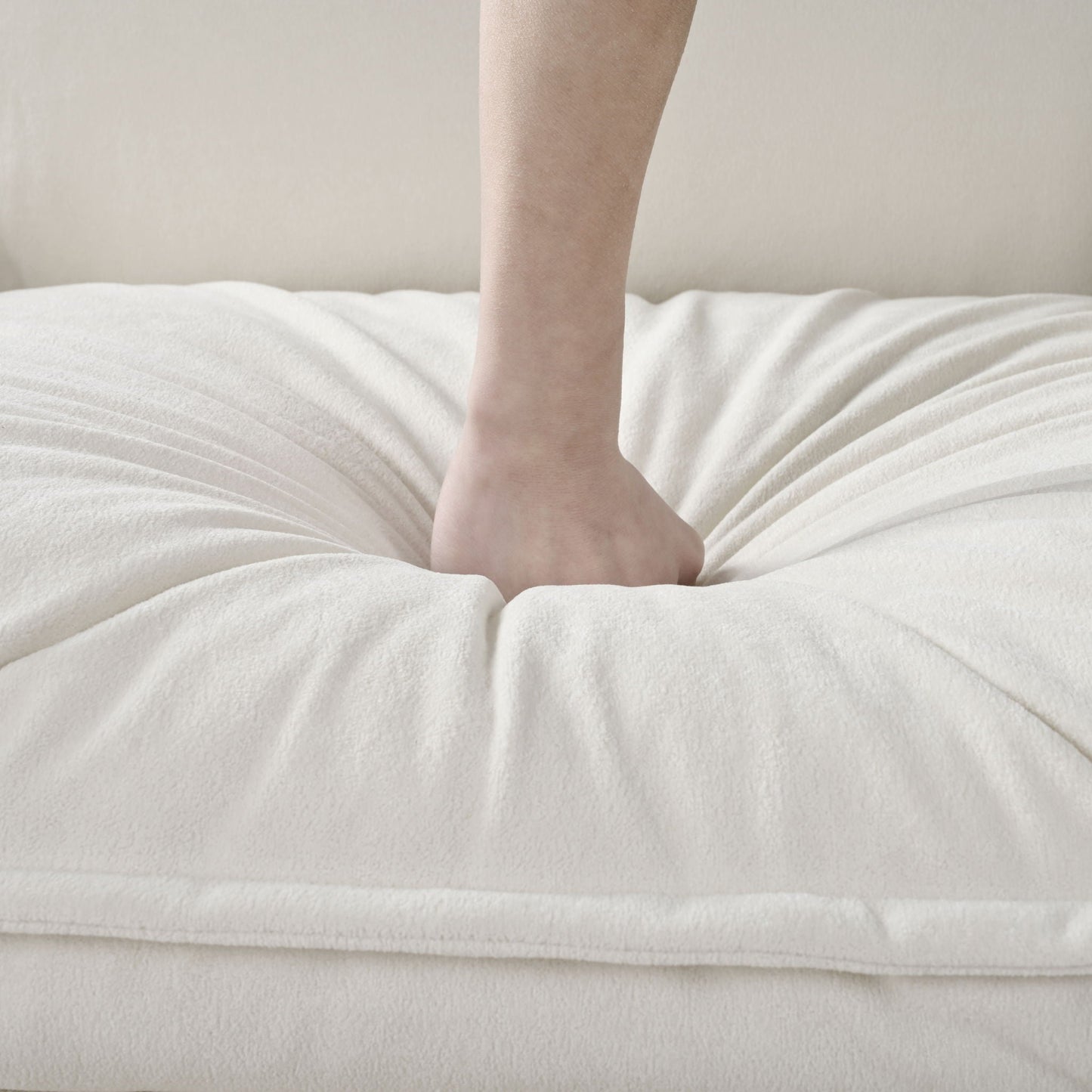 Bare leg resting on a plush white blanket, beige wall backdrop on Tampa Home & Garden Store