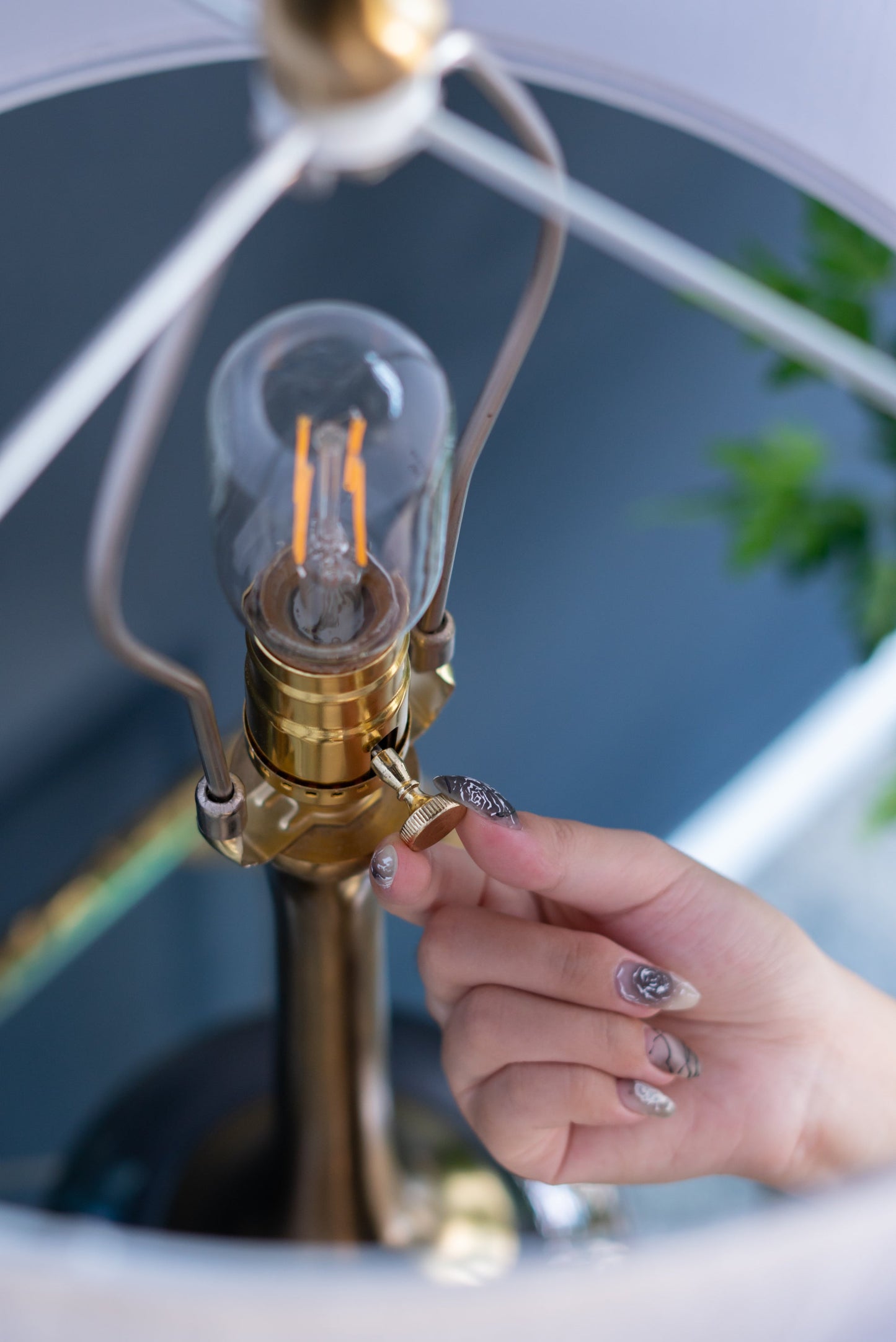 D15x29 Table Lamp with Glass Drum Shade brass metal base and clear bulb held by hand on Tampa Home & Garden Store