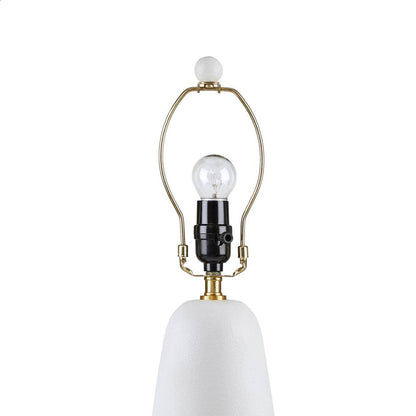 Textured white ceramic table lamp with brass arch frame, clear bulb, and white fluted shade on Tampa Home & Garden Store