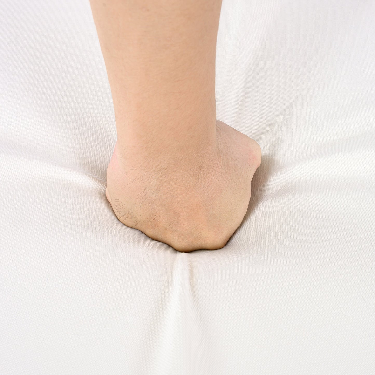 Bare ankle and lower leg close-up resting on white fabric background on Tampa Home & Garden Store