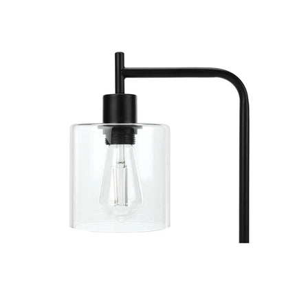 Table lamp with black metal frame and clear glass shade around a visible bulb on Tampa Home & Garden Store