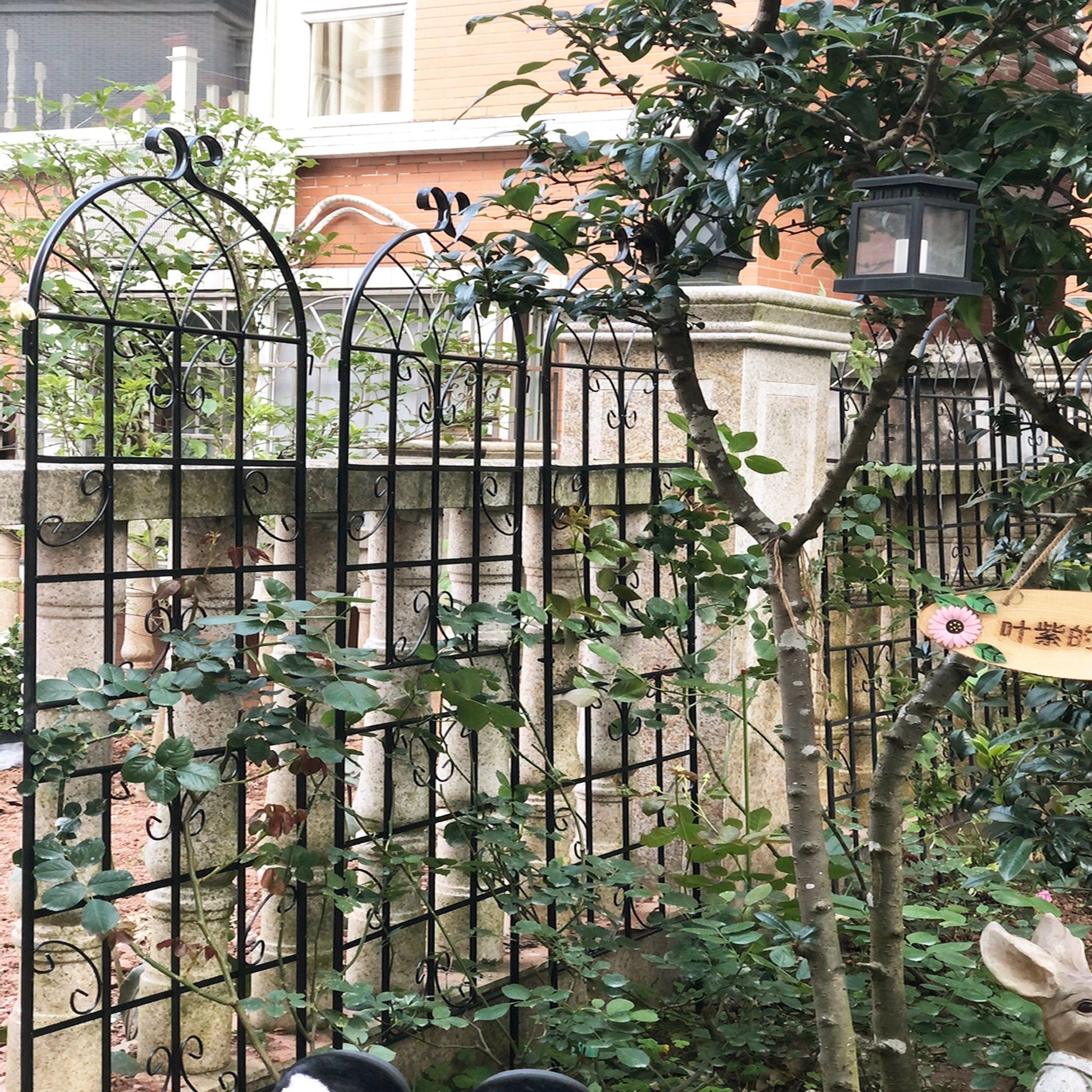 Black wrought-iron garden trellises with curved arch tops for climbing plants on Tampa Home & Garden Store