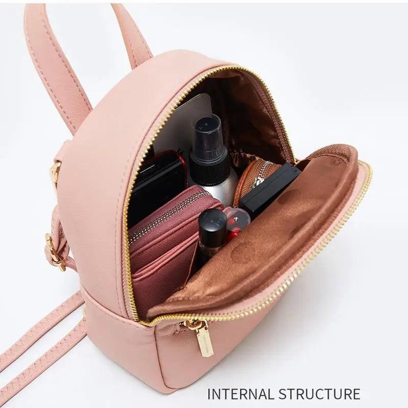 Pink mini soft-touch leather backpack opened to reveal makeup items and phone inside on Tampa Home & Garden Store