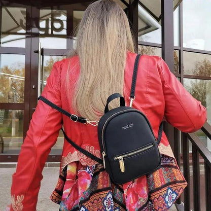 Stevvex mini soft touch leather backpack black with gold zipper worn by woman in red jacket on Tampa Home & Garden Store