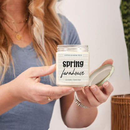 Cotton Blossom Candle by Gia Roma in a clear glass jar with lid held by a person on Tampa Home & Garden Store
