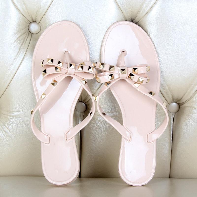Pair of pale pink Stevvex bow-knot flip flops with pyramid-studded straps on Tampa Home & Garden Store