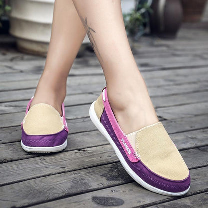 Pair of women’s slip-on espadrille flats in beige canvas with purple trim and white sole on Tampa Home & Garden Store