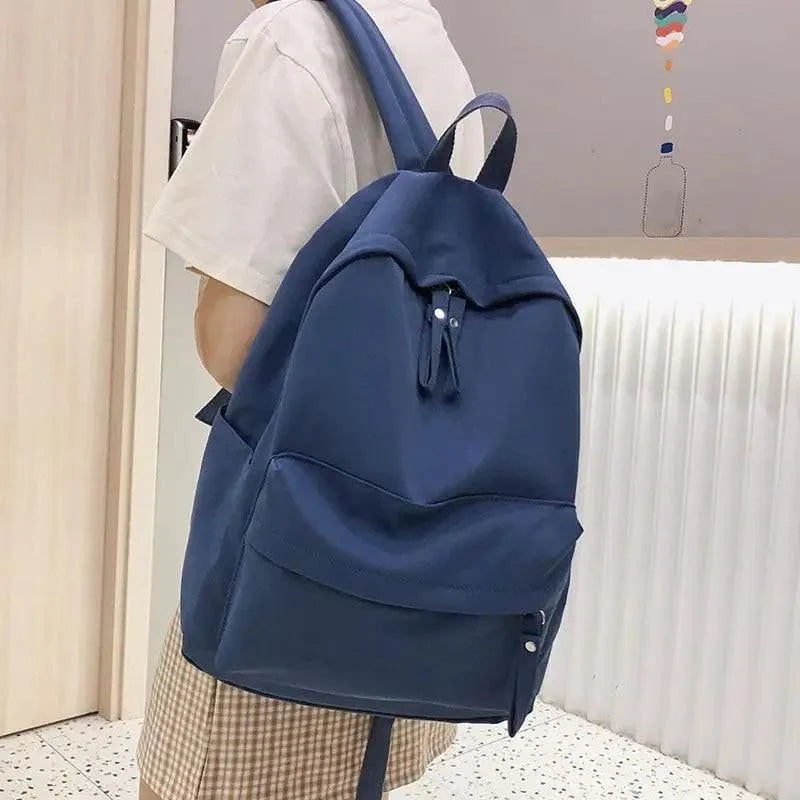 Stevvex laptop backpack navy blue solid color with front zip pocket carried by teen girl on Tampa Home & Garden Store