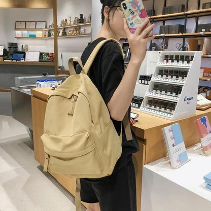 Laptop backpack Stevvex beige for teens with front zip pocket worn by a girl in a store on Tampa Home & Garden Store
