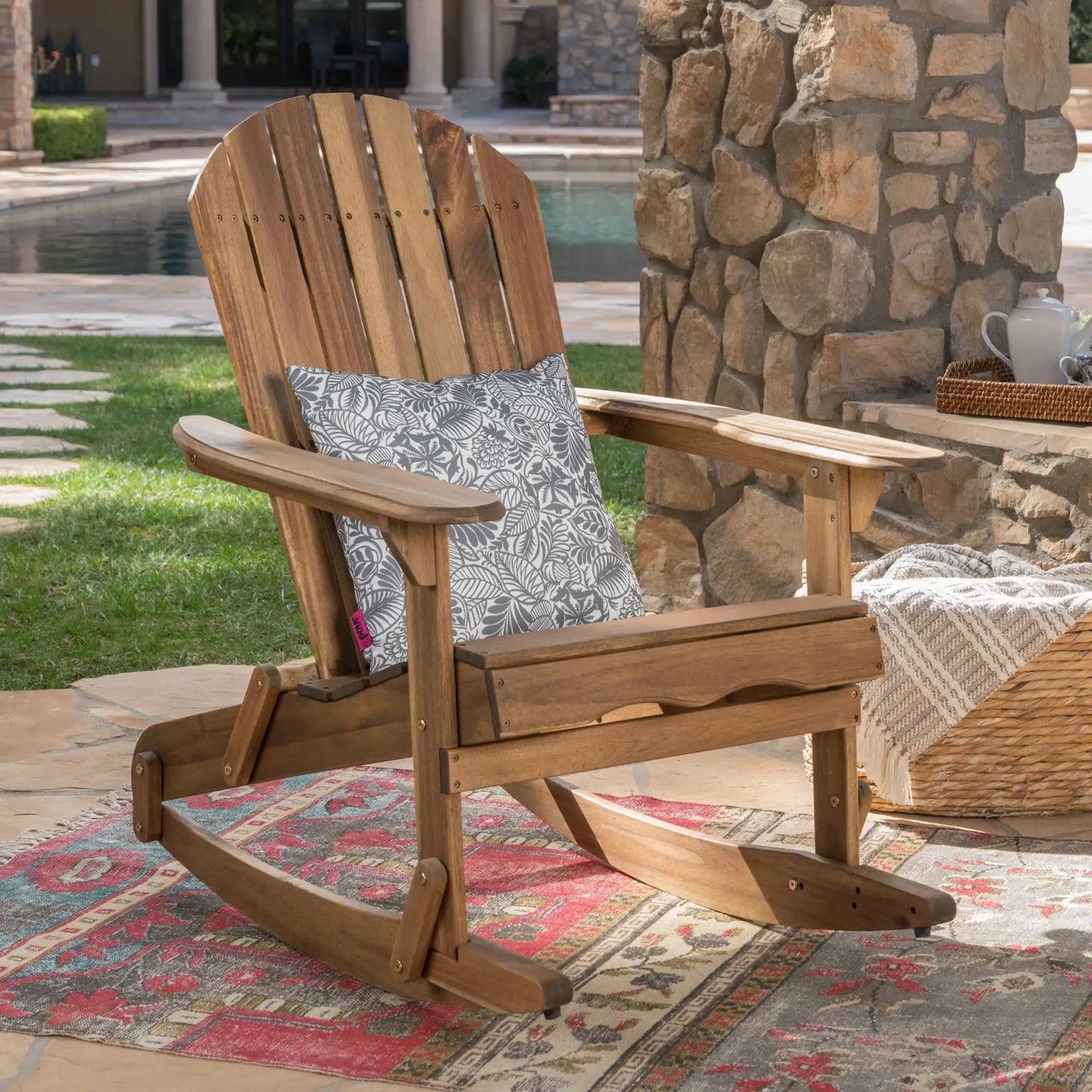 Outdoor Adirondack rocking chair with hand crafted details, natural wood and grey cushion on Tampa Home & Garden Store