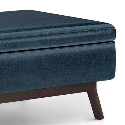 Owen upholstered rectangular storage ottoman in blue velvet fabric with dark wood legs on Tampa Home & Garden Store