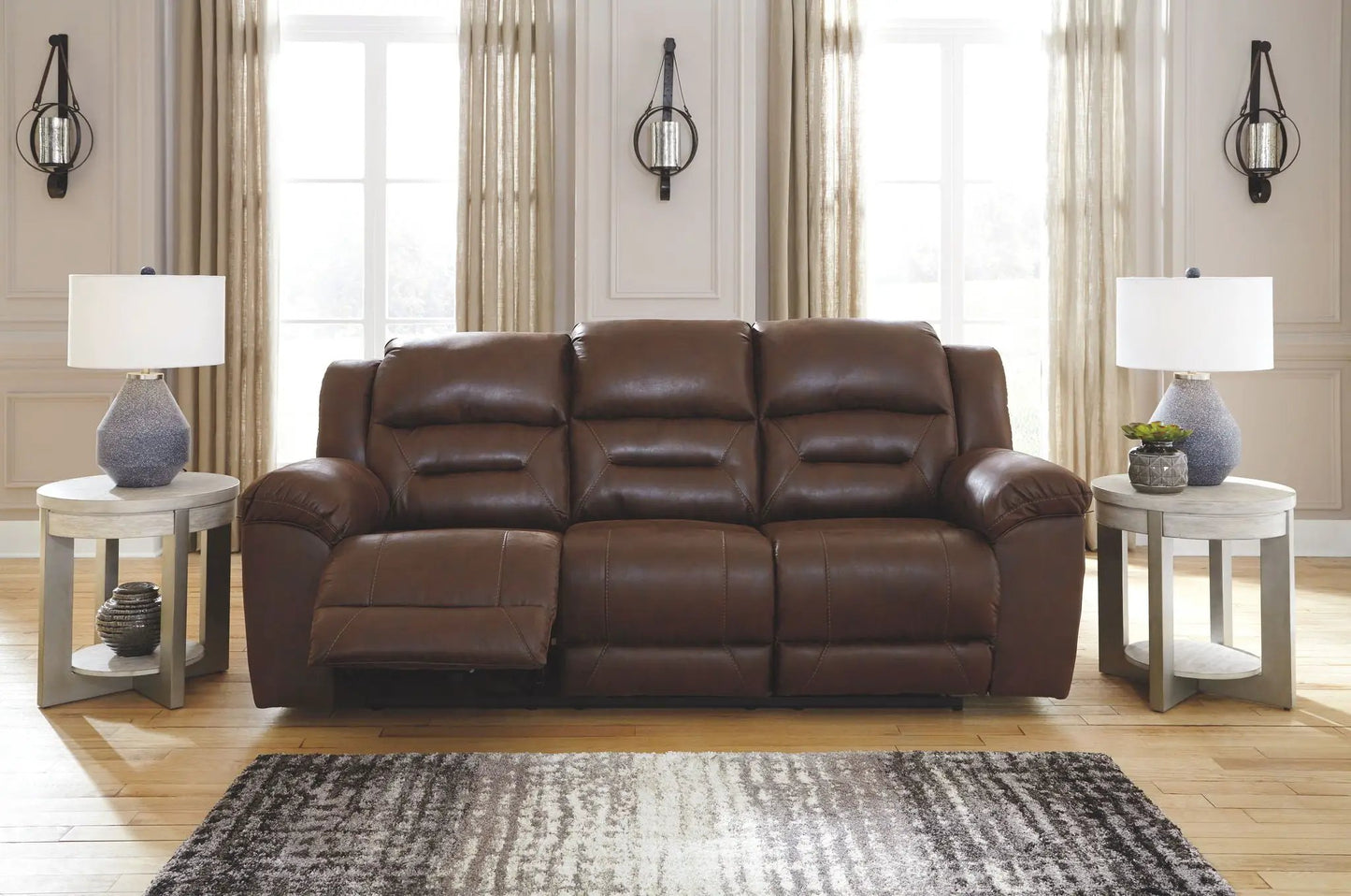 Stoneland reclining leather sofa in brown with tufted cushions and modern end tables on Tampa Home & Garden Store