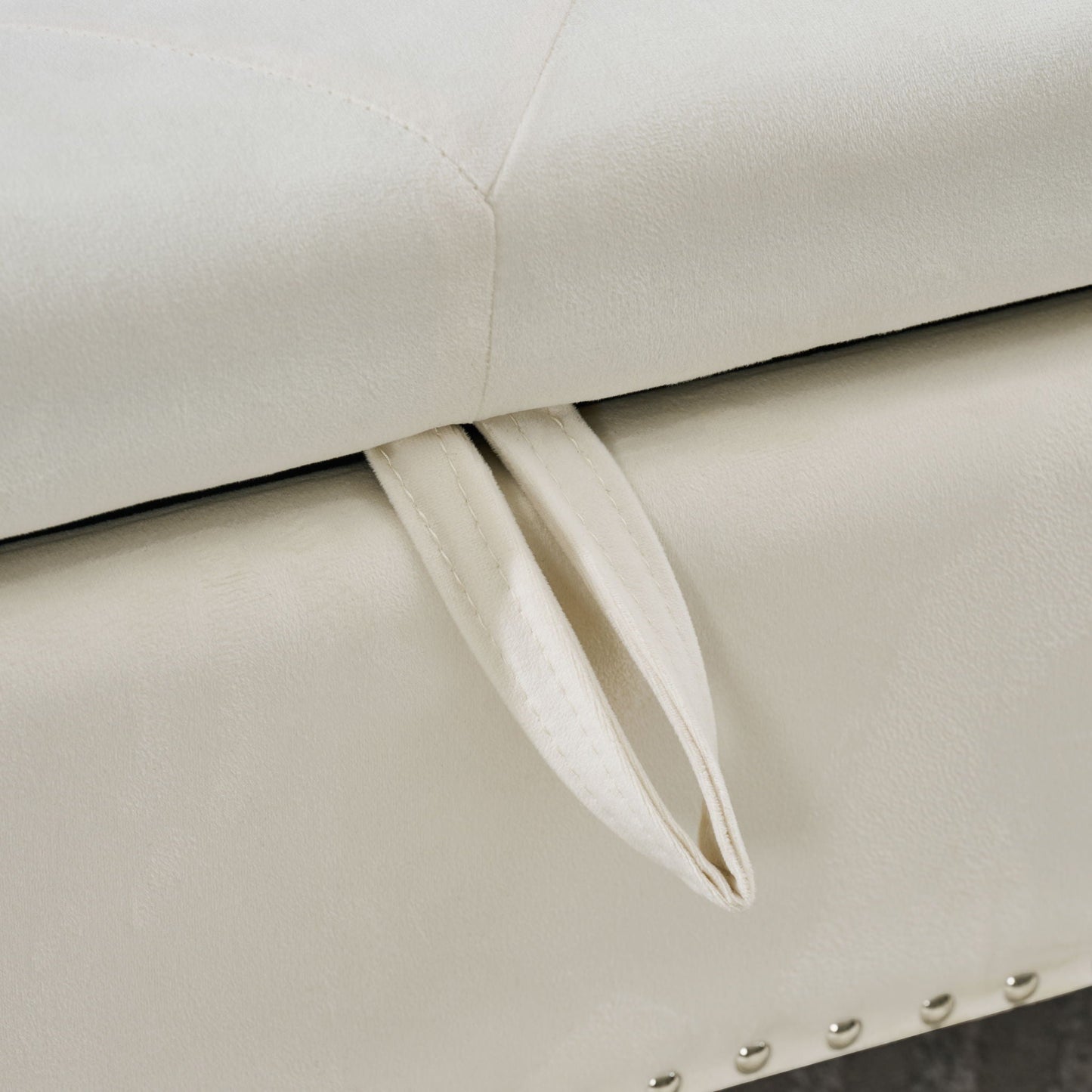 Storage bench upholstered in cream fabric with tufted lid and metal studded trim on Tampa Home & Garden Store