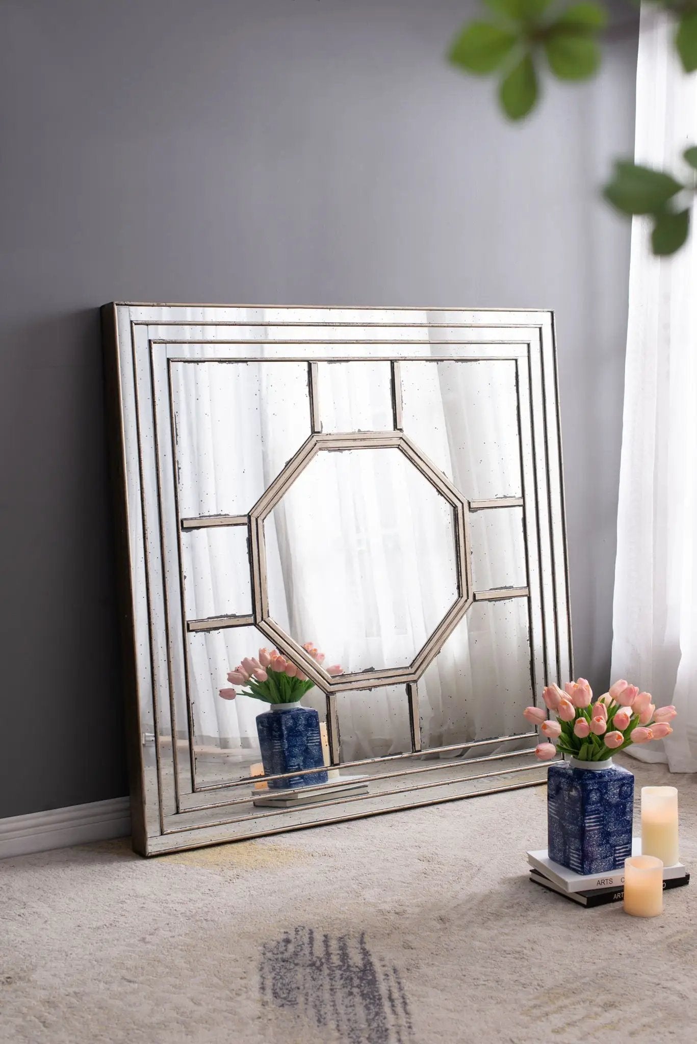 Antique square wall mirror with silver frame leaning on wall; two blue tulip vases nearby on Tampa Home & Garden Store