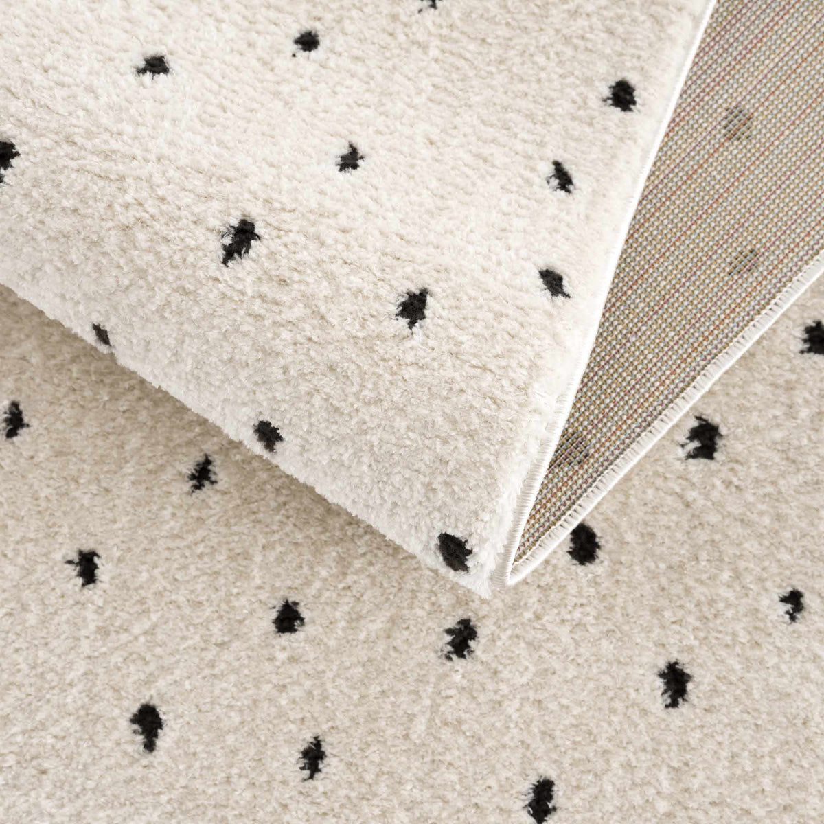 Julie Area Rug by Boutique Rugs, cream shag with black dot motifs; woven backing on Tampa Home & Garden Store