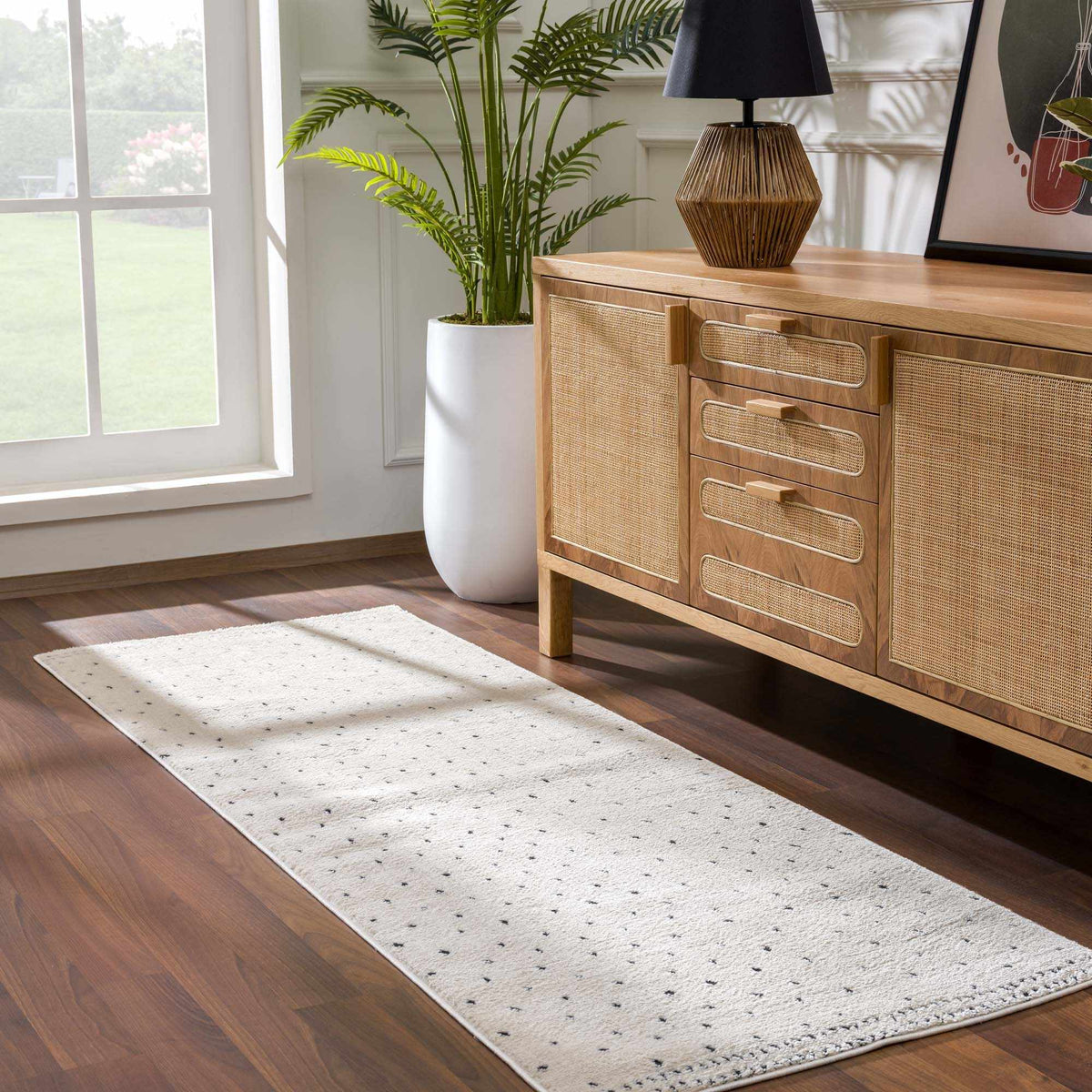 Julie Area Rug by Boutique Rugs, cream woven rug with small black dots beside a wooden dresser on Tampa Home & Garden Store