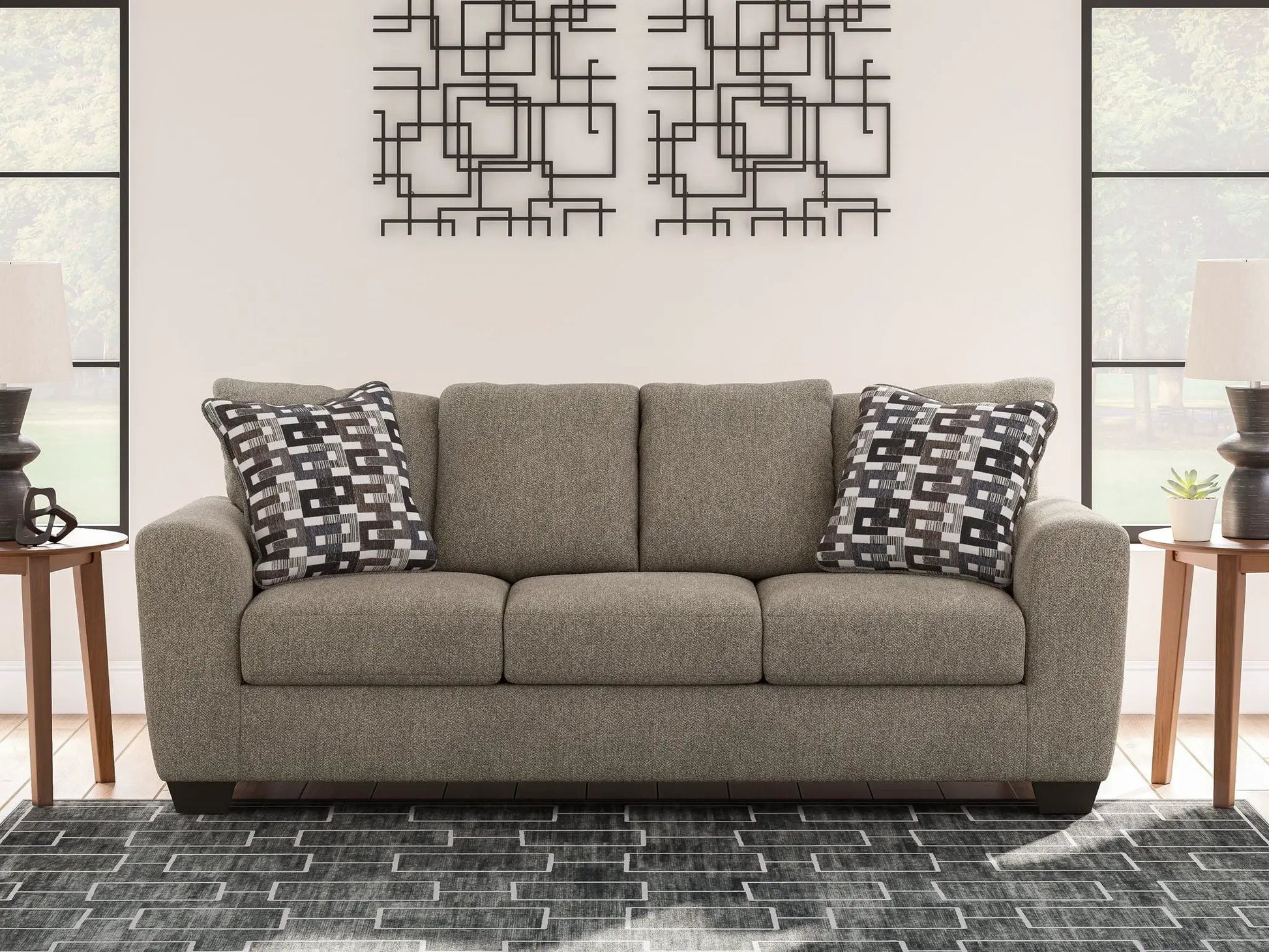 Triston-Peaks suede stationary sofa in gray upholstery with two geometric throw pillows on Tampa Home & Garden Store