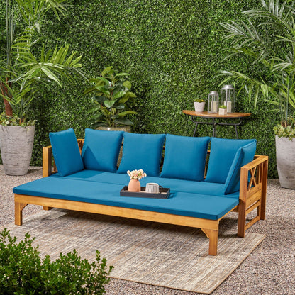 Outdoor teak daybed with blue cushions by HouseOfZazla, set against lush greenery on Tampa Home & Garden Store