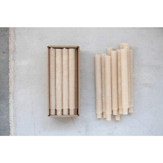 Beige unscented tapered candles in a box with several candles on a gray surface on Tampa Home & Garden Store