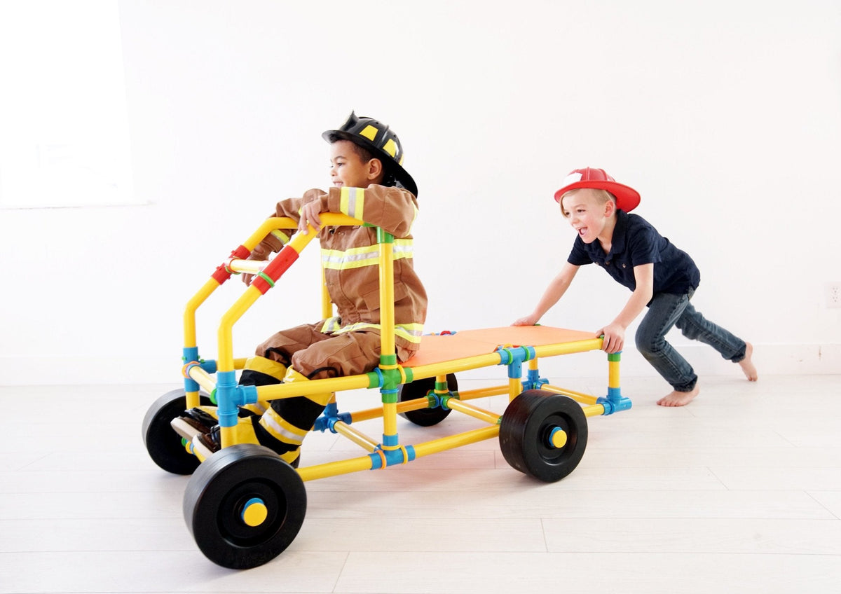 TubeLox Deluxe Set STEM toy two kids push a colorful yellow blue red wheeled tube frame on Tampa Home & Garden Store