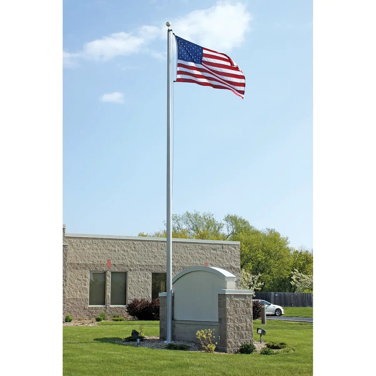 Aluminum external-rope flagpole by Flagman of America with waving flag over an office on Tampa Home & Garden Store