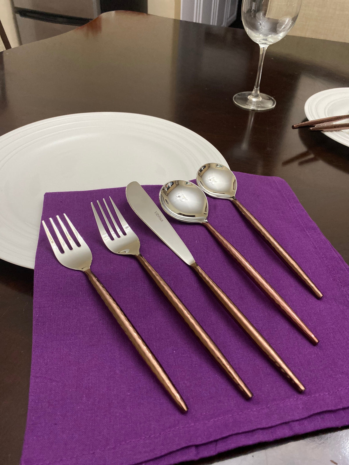 Hammered stainless steel flatware with brown copper handles, 5-piece display on purple napkin on Tampa Home & Garden Store