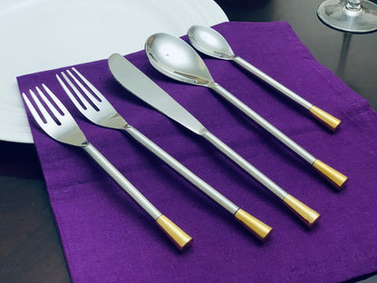 Vibhsa 20-piece silver flatware set for 4 with gold-toned handles on a purple napkin on Tampa Home & Garden Store