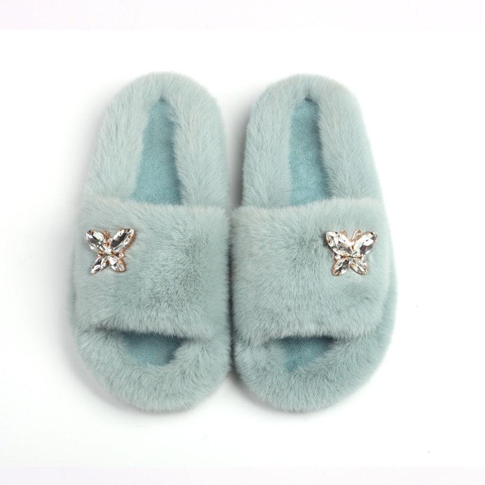 Women Stevvex faux fur slippers pair with rhinestone butterfly accents in light blue on Tampa Home & Garden Store