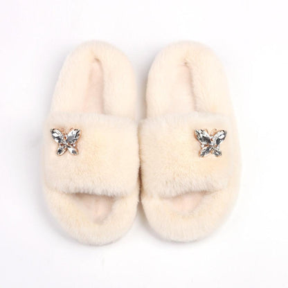 Women Stevvex faux fur slippers, beige with rhinestone butterfly accents, pair on Tampa Home & Garden Store