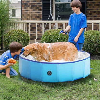 Foldable blue PVC dog pool in yard with a golden retriever in water as two kids wash him on Tampa Home & Garden Store