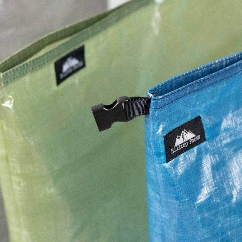 Blue ultralight DYNEEMA Bear bag food bag with black buckle clip; Hilltop Packs logo, green bag behind on Tampa Home & Garden Store