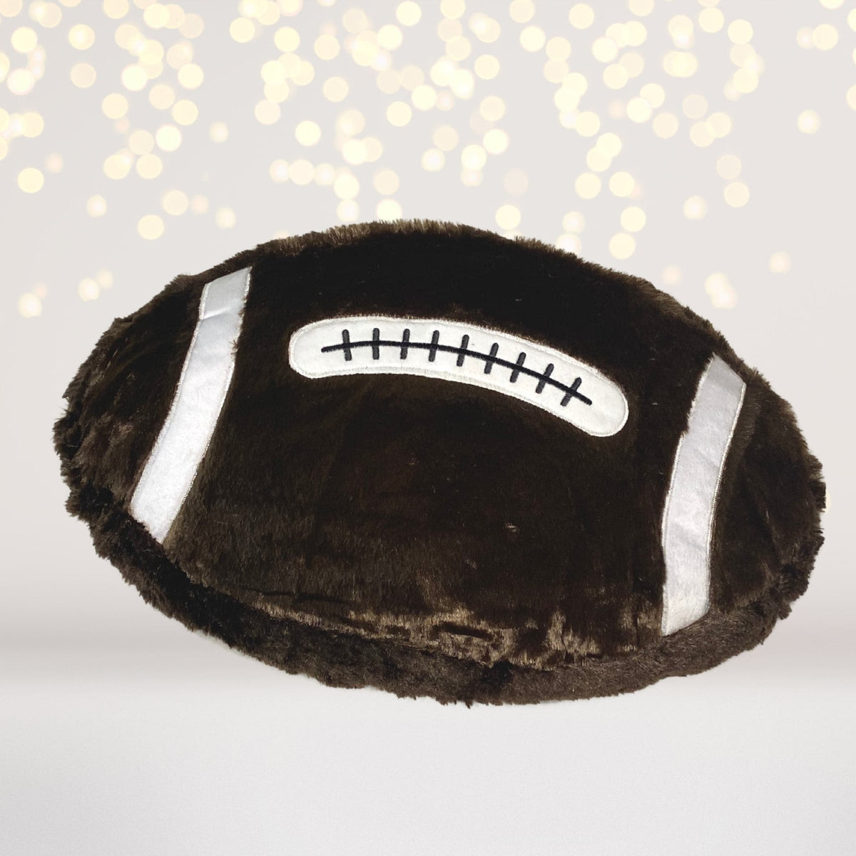 Sports plush throw pillow with dark brown fur and silver straps, features stitched patch on Tampa Home & Garden Store