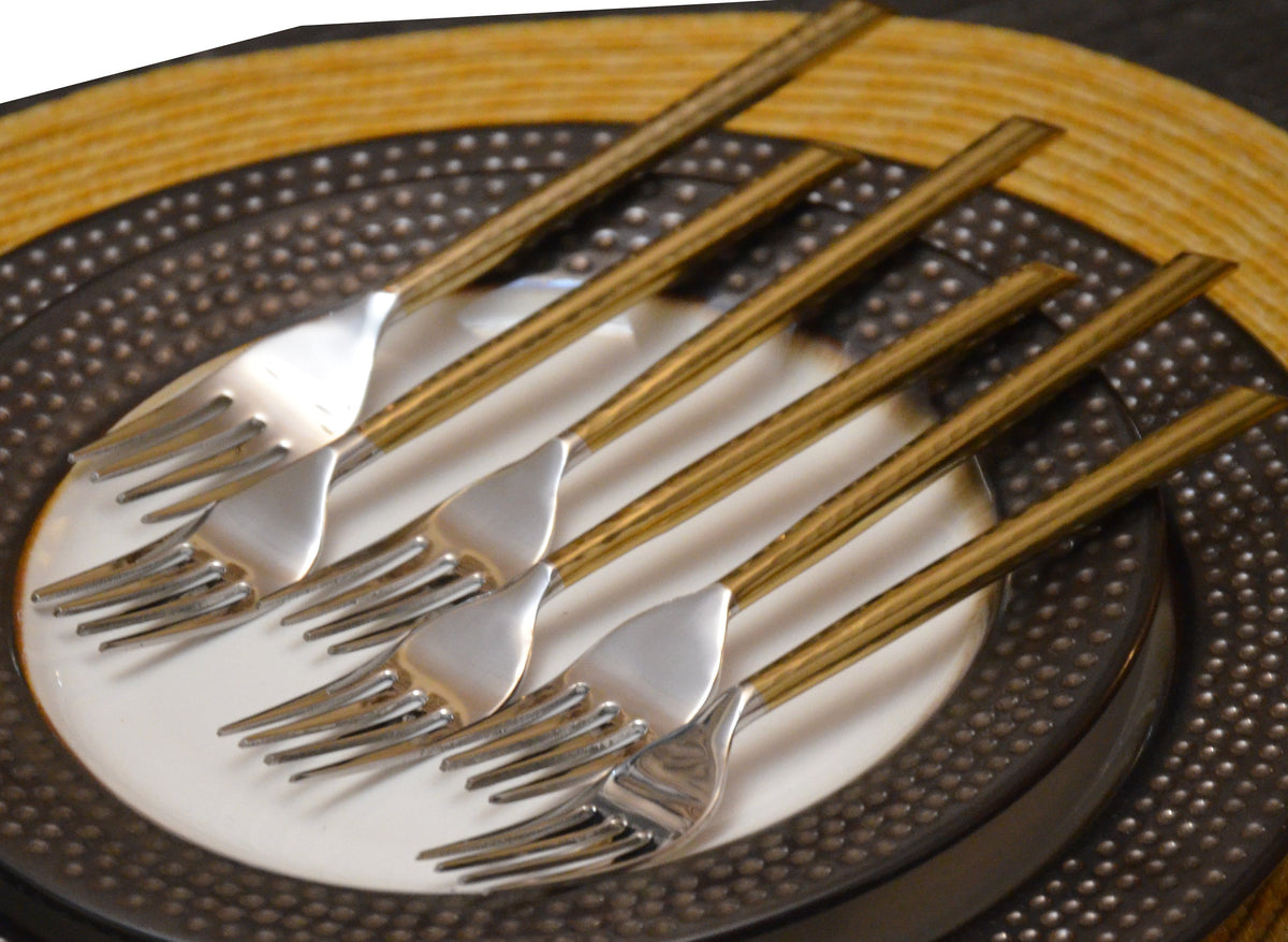 Gold stainless steel dinner forks set of 6 with striped handles on a textured charger plate on Tampa Home & Garden Store