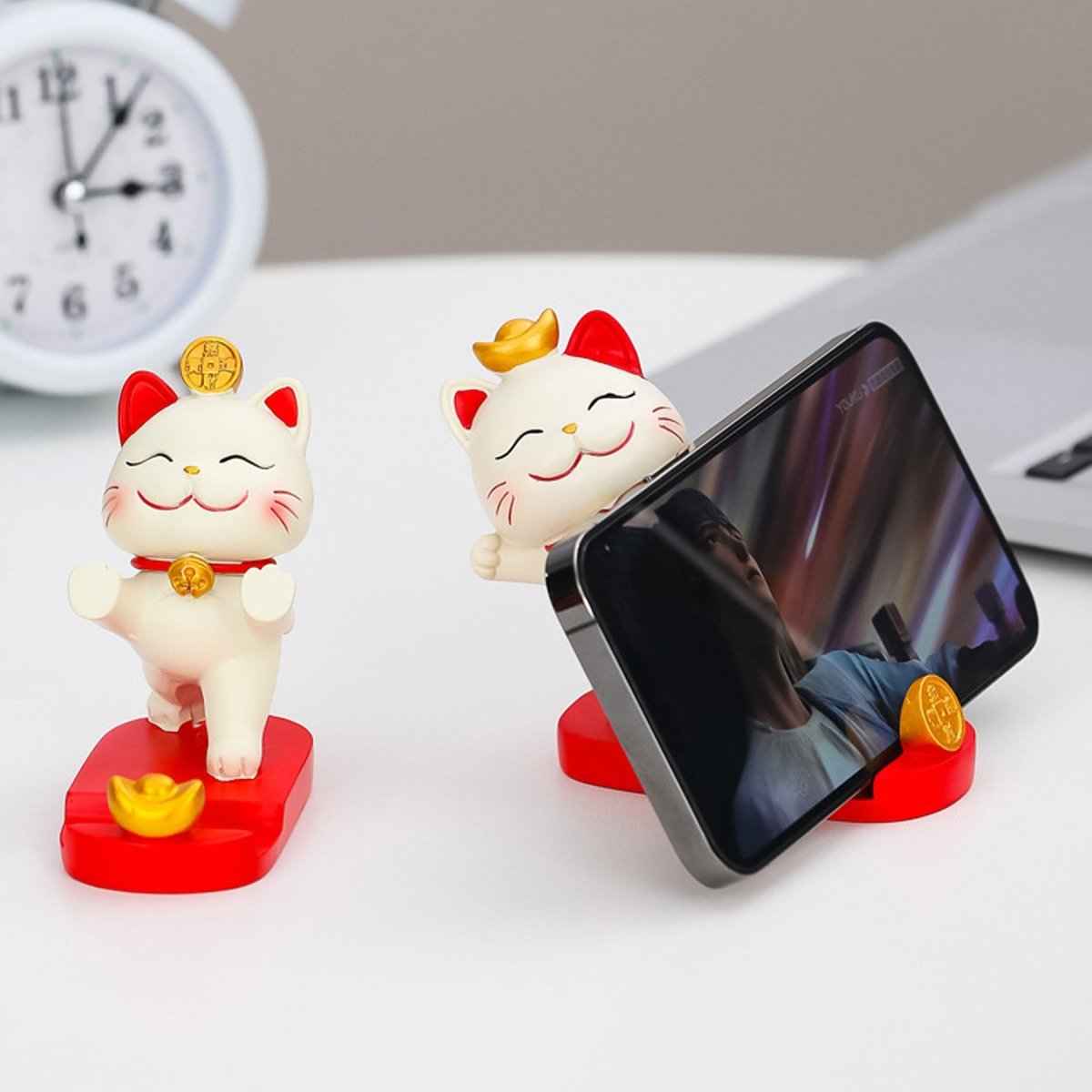 Two white Shaketea fortune cat phone stands on red bases, one with coin atop head on Tampa Home & Garden Store
