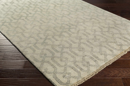 Fairborn Wool Rug by Boutique Rugs in cream with geometric pattern and fringe on wood floor on Tampa Home & Garden Store