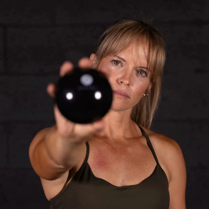 Orbit muscle release tool by Aletha Health, black spherical massage ball held toward camera on Tampa Home & Garden Store