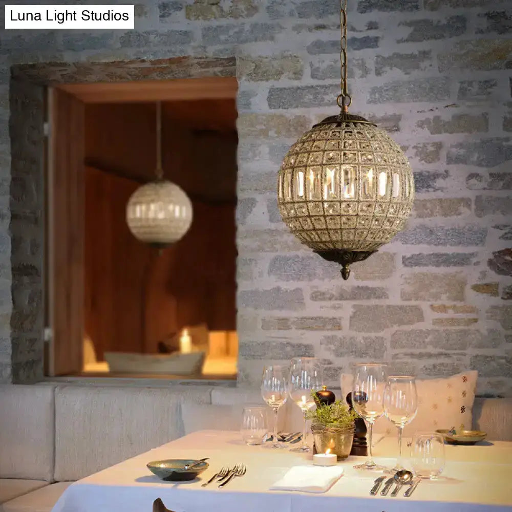 French Country Globe Brass Crystal Chandelier by Decorbites over a dining table on Tampa Home & Garden Store