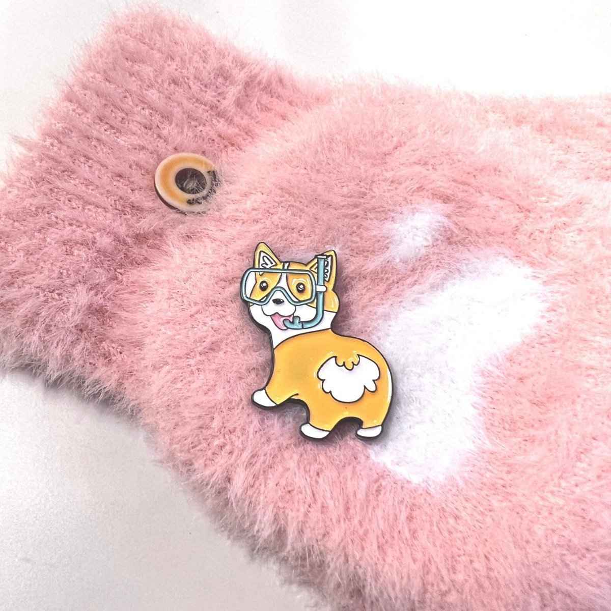 Fun corgi enamel pin with diving goggles on pink fluffy backdrop on Tampa Home & Garden Store