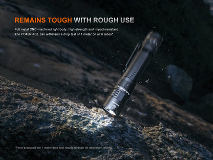 Fenix PD45R ACE tactical flashlight with black CNC-metal body and rugged grip on rocky terrain on Tampa Home & Garden Store