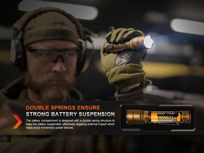 Fenix TK20R UE tactical LED flashlight bronze finish held by gloved hand, 2800-lumen beam on Tampa Home & Garden Store