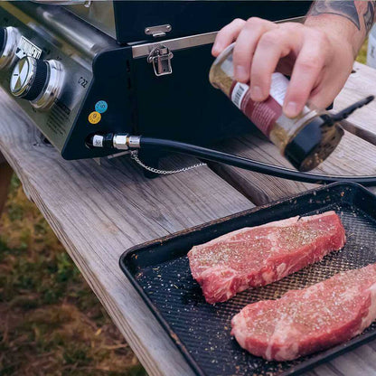 G22 stainless tabletop propane grill by Monument Grills on table two steaks on a tray nearby on Tampa Home & Garden Store