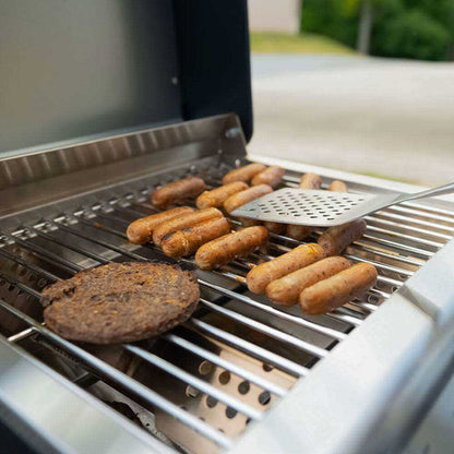Monument Grills G22 stainless tabletop propane grill with sausages and burger patty on Tampa Home & Garden Store