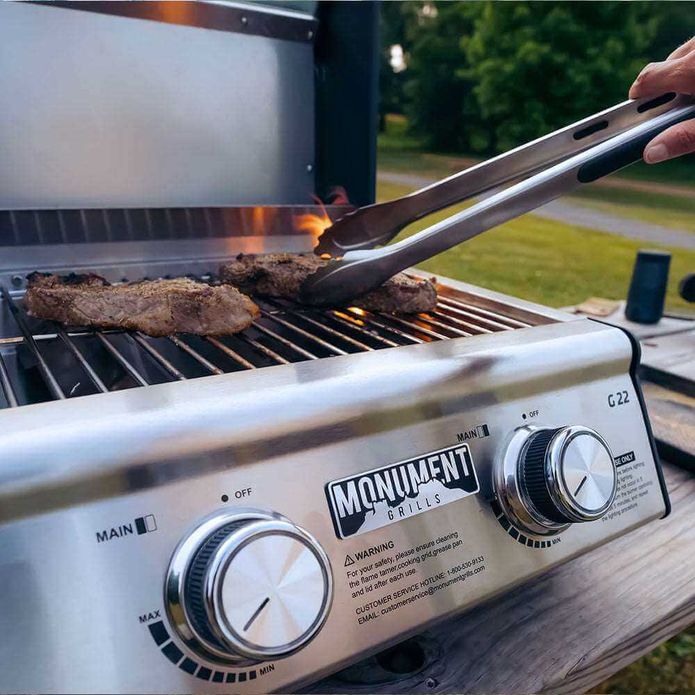G22 stainless tabletop propane grill by Monument Grills cooking two burgers on stainless grate on Tampa Home & Garden Store