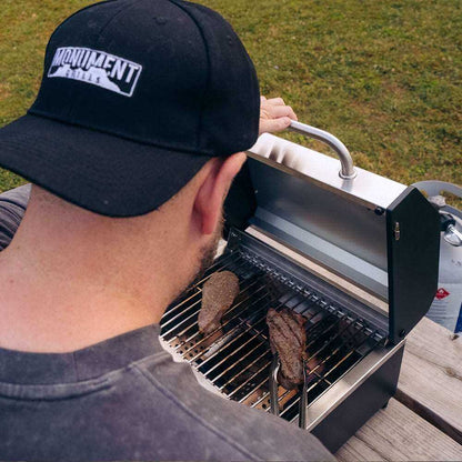 Monument Grills G22 stainless tabletop propane grill grilling two steaks on Tampa Home & Garden Store